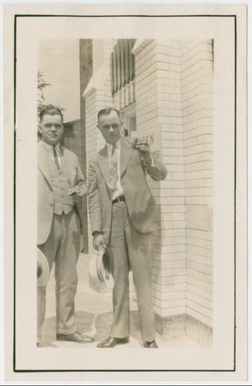 Walt Anderson and Billy Ingram eating White Castle hamburgers outside a White Castle building in the 1920s.