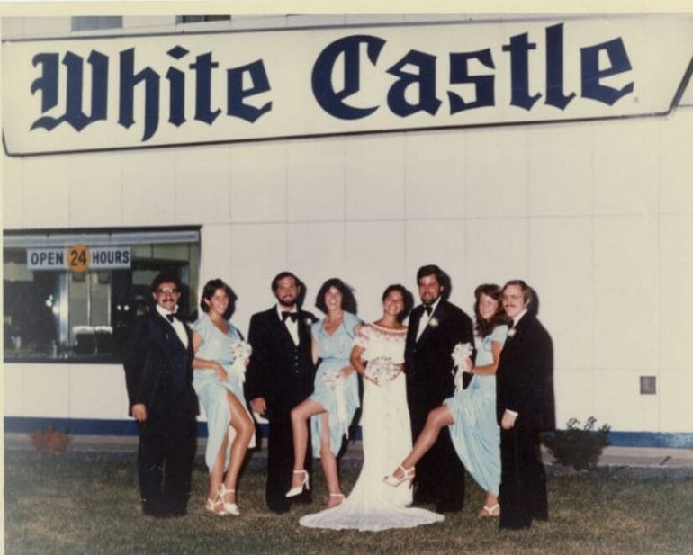 A wedding party poses for a picture in front of a White Castle restaurant.