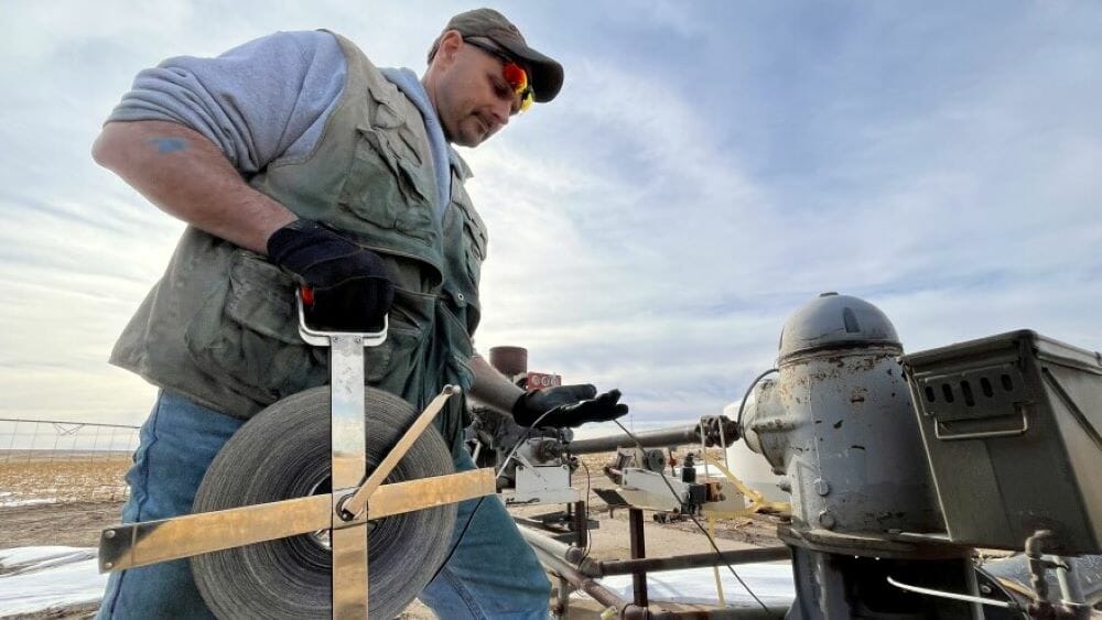 Brownie Wilson of the Kansas Geological Survey uses a metal measuring tape to determine the depth of the aquifer's water level in western Kansas. Statewide aquifer levels dropped by nearly two feet over the past year — this third-largest decline since the 1990s.