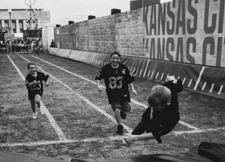 Three children racing at the NFL Experience during the NFL Draft.