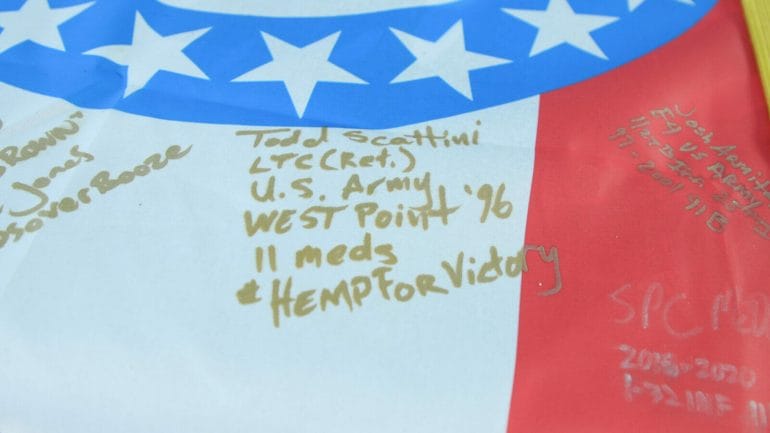 gold marker on a Missouri State Flag reads "Todd Scattini LTC (ret.) U.S. Army West POint '96 11 Meds #hempForVictory"