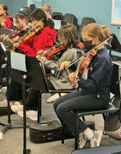 Six young people playing the violin at Harmony Project KC.