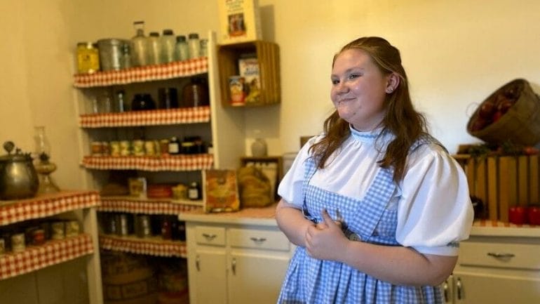 The museum's tour guides remain steadfastly in character as Dorothy Gale while on the job. Here, one guide tells visitors about the kitchen of the farmhouse she grew up in.
