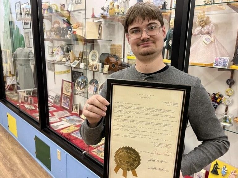 Museum director Nathan Dowell holds a framed document proclaiming Liberal as the official home of Dorothy Gale.