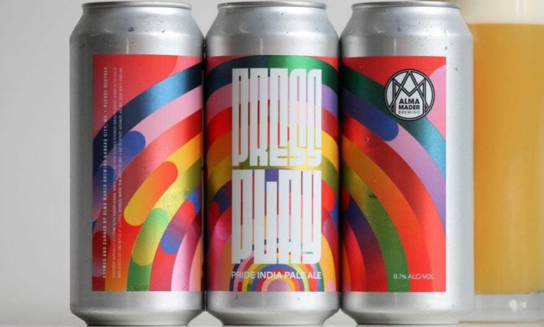 Three cans of Alma Mader's new Press Play beer featuring pride flags on the label.