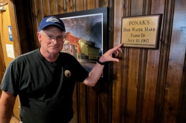 John Greer shows the high water mark from the 1993 flood at Ponak's.