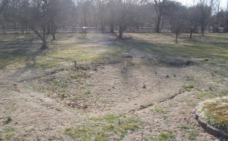 A sunken hole, known as subsidence, in a field.