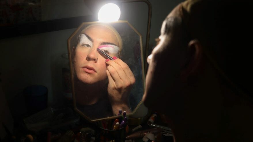 Kiki Cobra applying makeup.