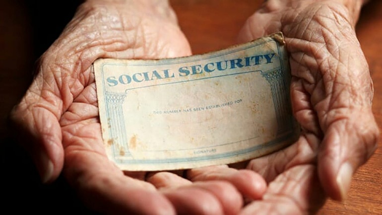 Two hands holding a Social Security card.