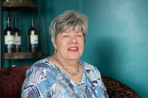 Portrait of an older woman with short hair and a blue shirt.