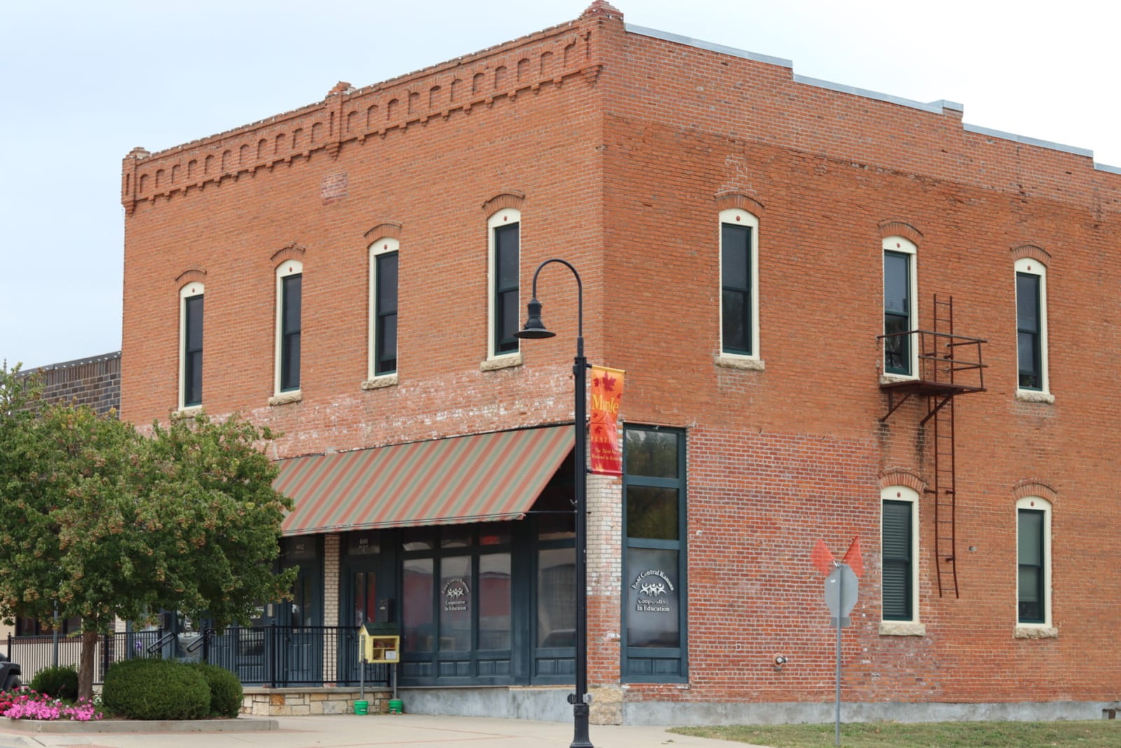 A square, red brick building with white, arched windows and brick molding on top.