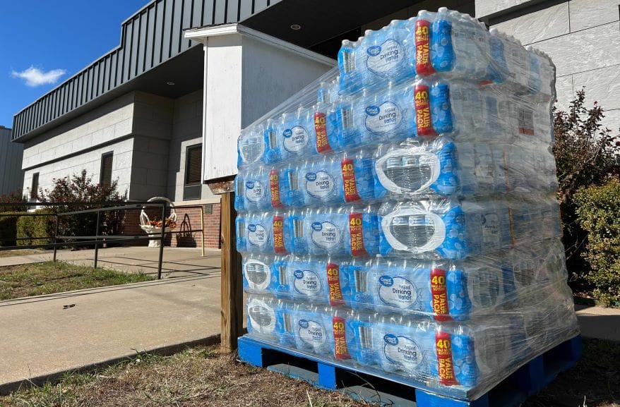 Cases of bottled water sit in front of Caney City Hall.