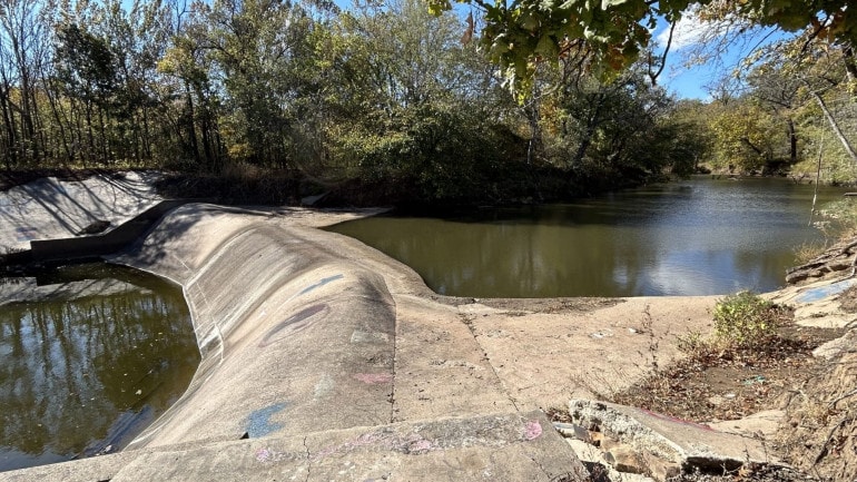 Water levels in the Little Caney River are a foot below the dam, leaving what little water remains in the stream stagnant.