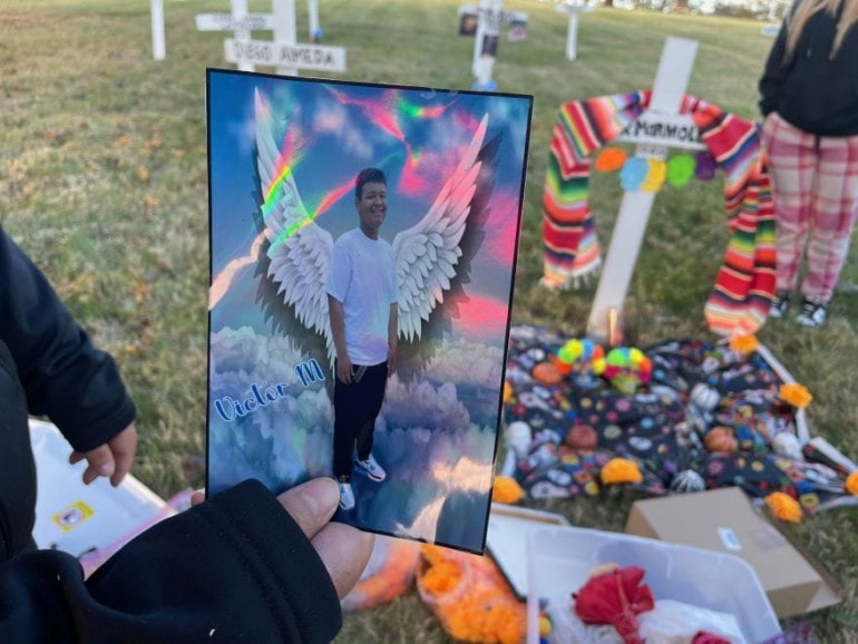 A picture of her son Victor as an angel is held by Jazmin Marmolejo, part of the decorations she brought to leave at a cross in his memory.