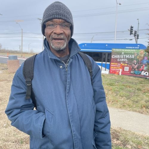 Willie Clark stands near a bus stop.