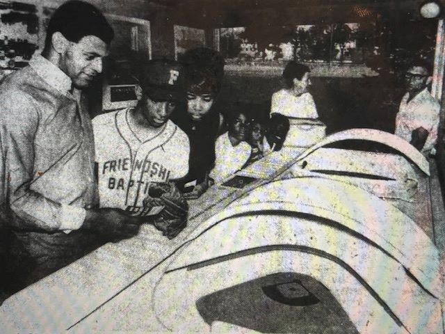 Kansas City Chiefs halfback Gene Thomas showing off a model of the original Truman Sports Complex design to area residents.