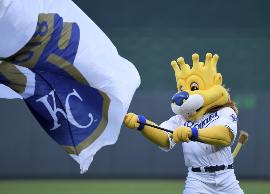 Kansas City Royals' mascot Sluggerrr waves the team flag.