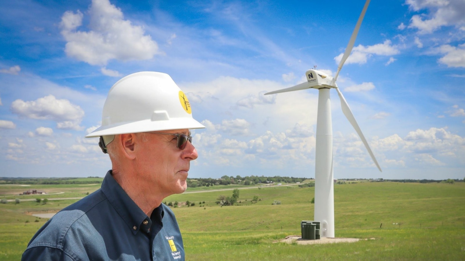 Bruce Graham stands in front of a wind turbine in Kansas.