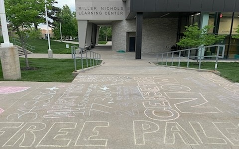 Students at UMKC covered sidewalks in a high traffic area near the Miller Nichols Learning Center with messages. Names, thousands of them, of Palestinians killed during the war between Israeli Defense Forces and Hamas were written in chalk.