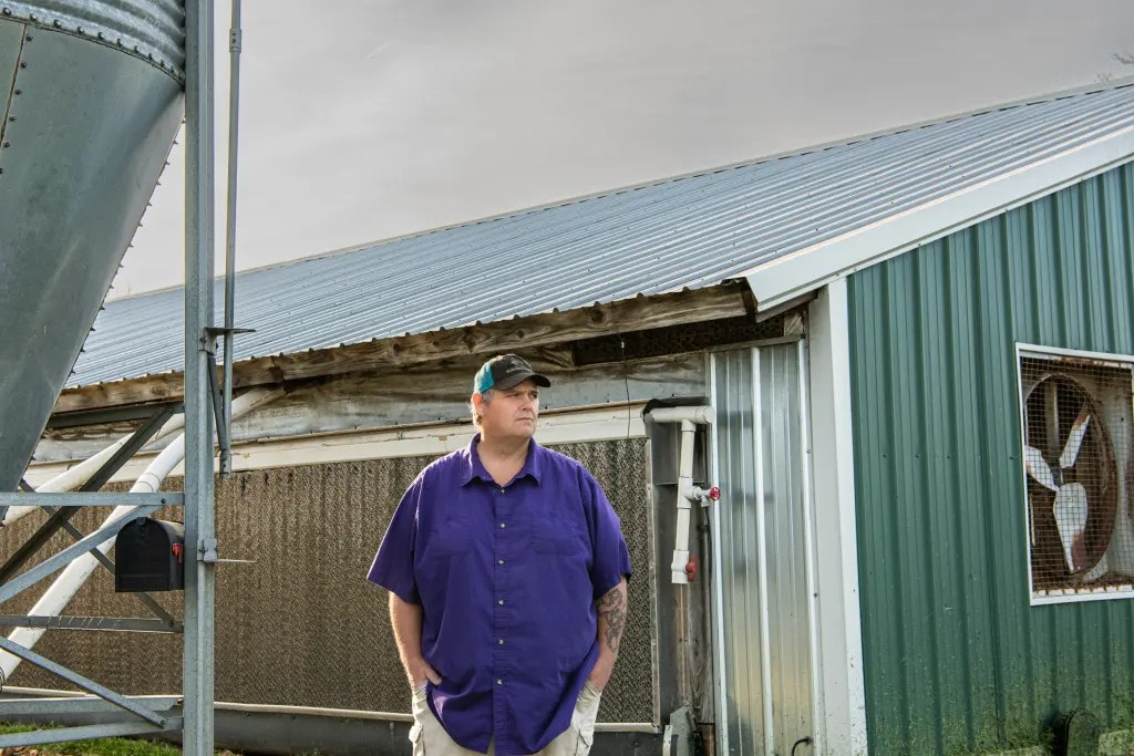 Timothy Bundren stands outside one of his empty chicken barns at his operation near Harrison, Arkansas.