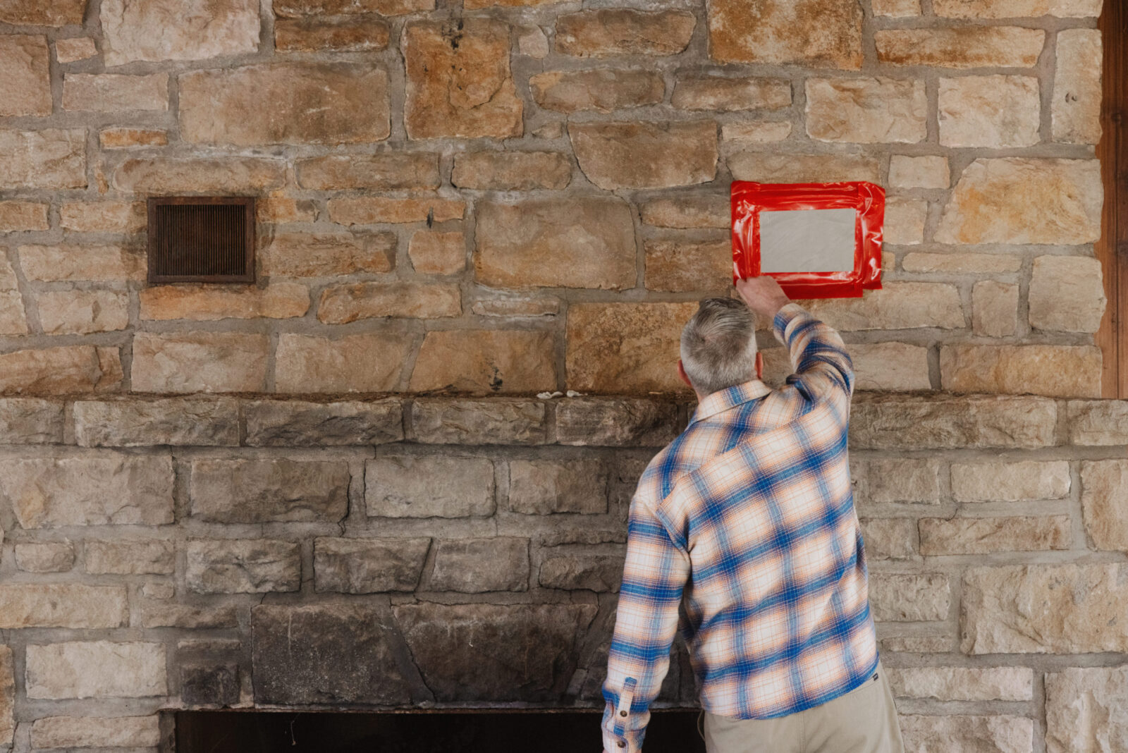 Kansas City Parks & Recreation Director Chris Cotten removes plastic sealing a fireplace vent at Hope Lodge in Swope Park. (Chase Castor | Flatland)
