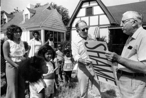 In this undated photo, lawyer Sidney Willens (center) and Fred Brunn, president of the Marlborough Neighbors Association, hold one of two "Shame of the Neighborhood" awards they posted Saturday on vacant houses at 7332 and 7334 Forest. Willens is representing several residents of the southeast Kansas City neighborhood who are concerned that dilapidated housing will threaten property values. These two houses were judged by neighbors to be the biggest eyesores in the area. (Photo Courtesy of The Kansas City Star)